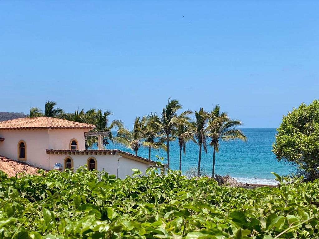a house on the beach with palm trees and the ocean at Summer Salt Beach Casita in Punta Mita