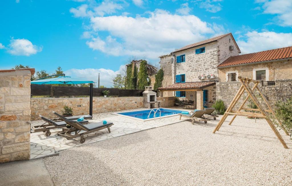 a patio with a swimming pool and a house at Cassa Antica with outdoor pool, near Poreč in Rapavel