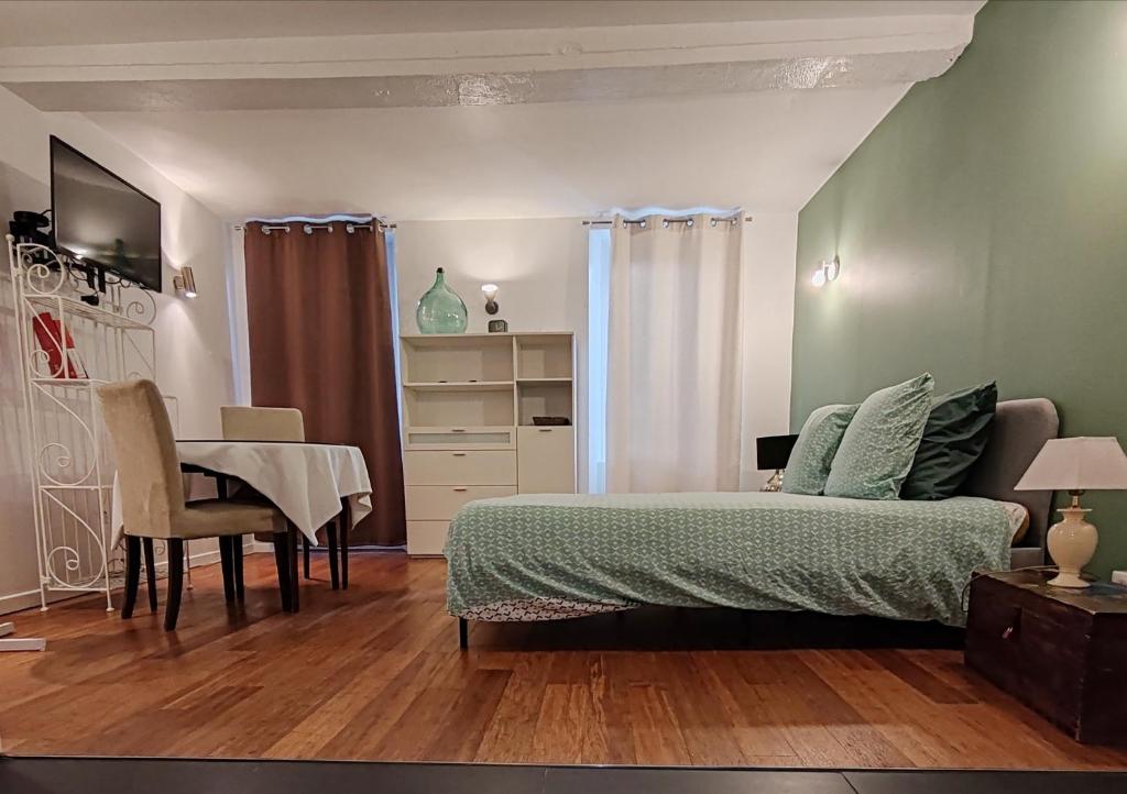 une chambre avec un lit, une table et un bureau dans l'établissement appart centre historique Picasso, à Vallauris