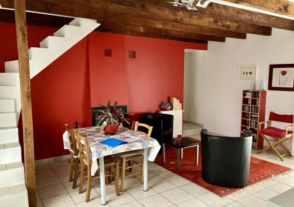une salle à manger avec une table et un mur rouge dans l'établissement Nantes a la campagne, à Pont-Saint-Martin