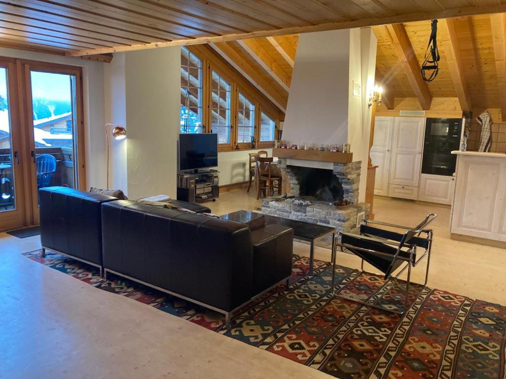 a living room with a couch and a fireplace at Villars SWISS Alpes in Villars-sur-Ollon