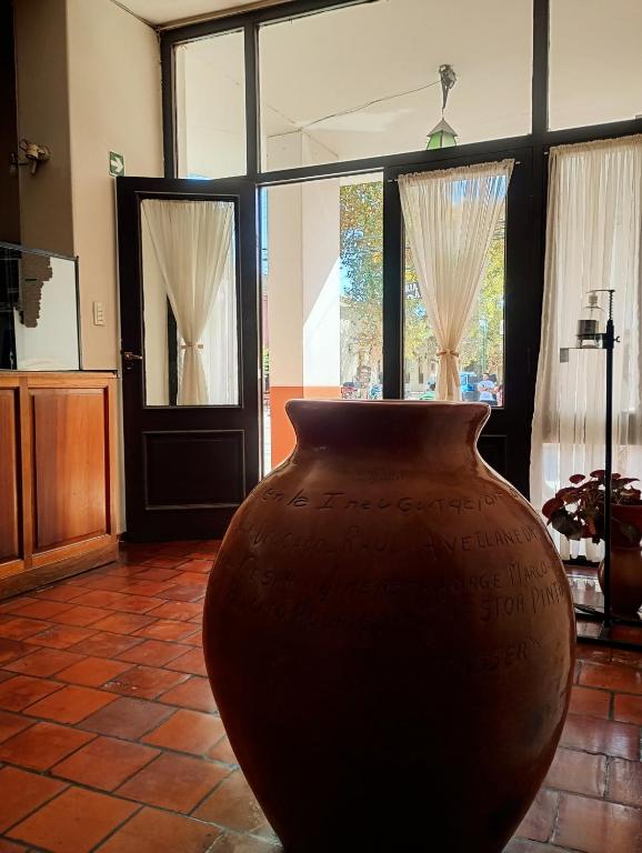 a large brown vase sitting in a room with windows at Hotel Asembal in Cafayate