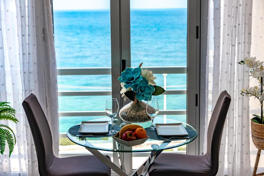 a table with a vase of flowers and a table with chairs at Estudio Loft Horizonte Playa Fossa Calpe in Calpe