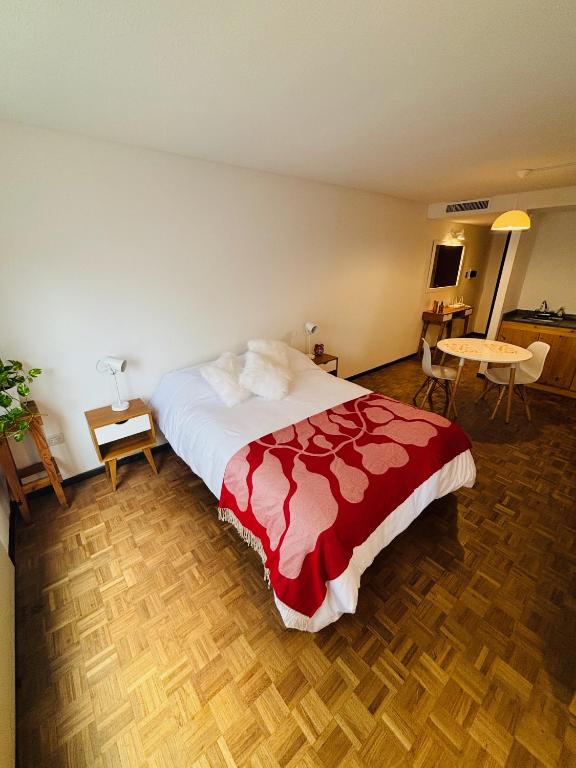 a bedroom with a large bed with a red blanket at Hermoso Apartamento en Edificio Saint Michel in Córdoba