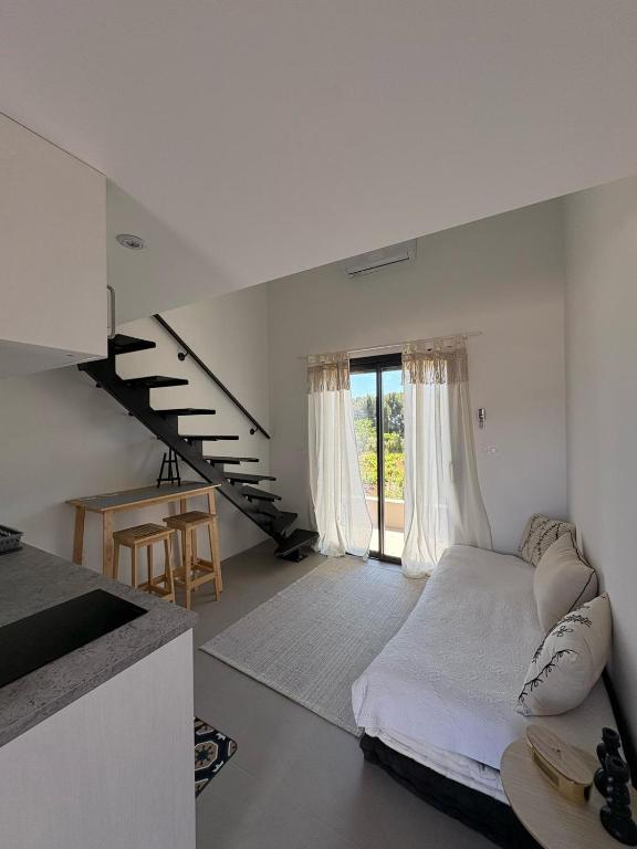 Cette chambre blanche dispose d'un lit et d'un escalier. dans l'établissement Studio terrasse aperçu mer vignes, à Saint-Cyr-sur-Mer