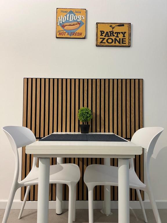 a white table with white chairs and a potted plant at Al Tribunale Guest House in Palermo