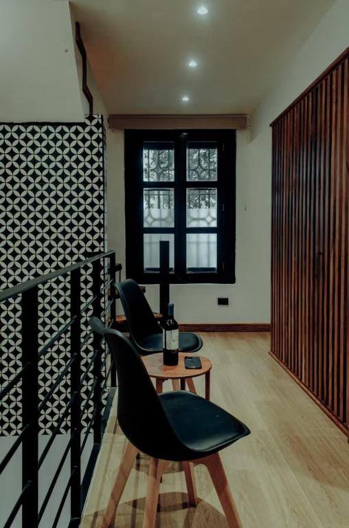 a room with two chairs and a table and a window at Casa del Árbol in Antigua Guatemala