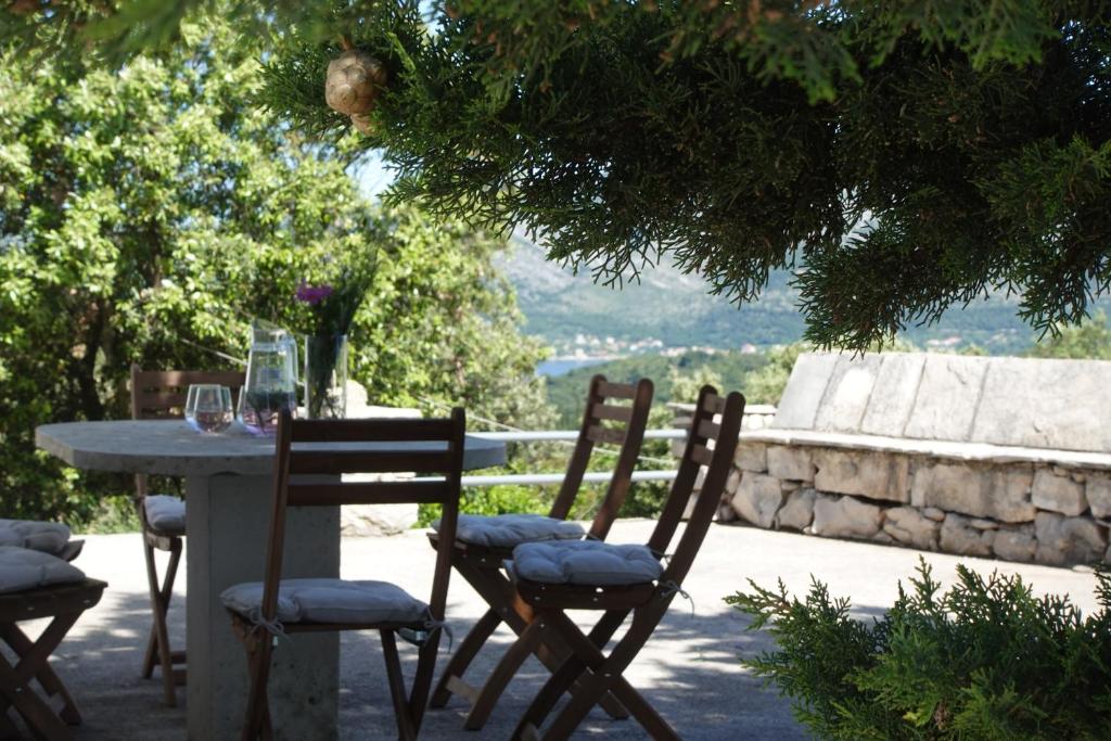 a table with two chairs and a table with wine glasses at Solar Hill Home in Žrnovo