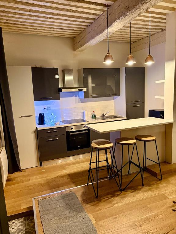 une cuisine avec deux tabourets de bar et un comptoir dans l'établissement Étoile du Vieux Lyon, à Lyon