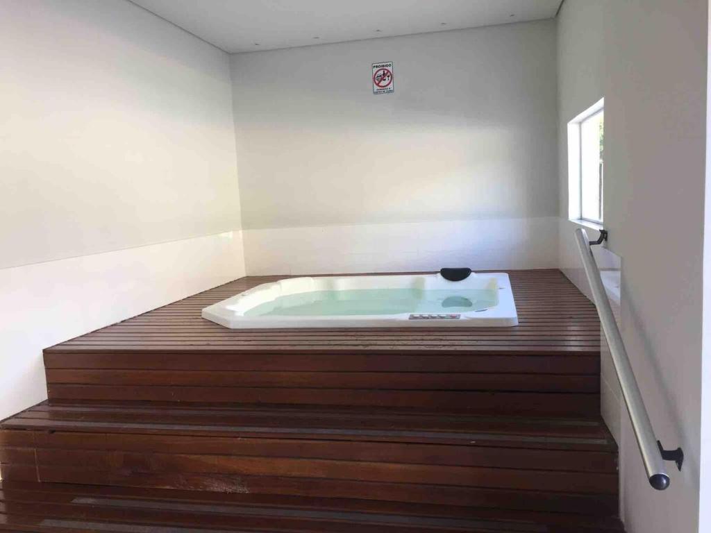 eine Badewanne in einem Zimmer mit Holzboden in der Unterkunft Flat em Itaipava! in Araras Petropolis