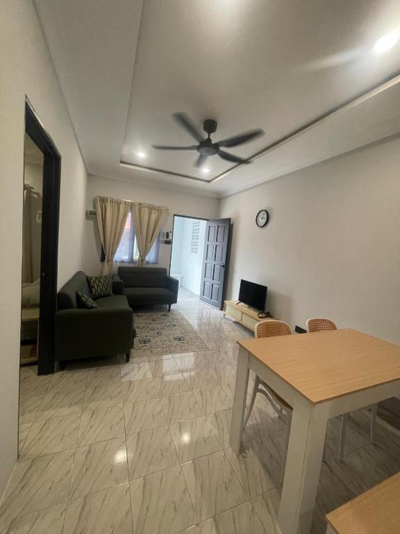 a living room with a couch and a ceiling fan at Tanah Embah RumahLima melayu sahaja in Banting