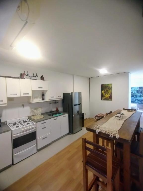 une grande cuisine avec des placards blancs et un grand îlot dans l'établissement Excelente Departamento en Nuñez, à Buenos Aires