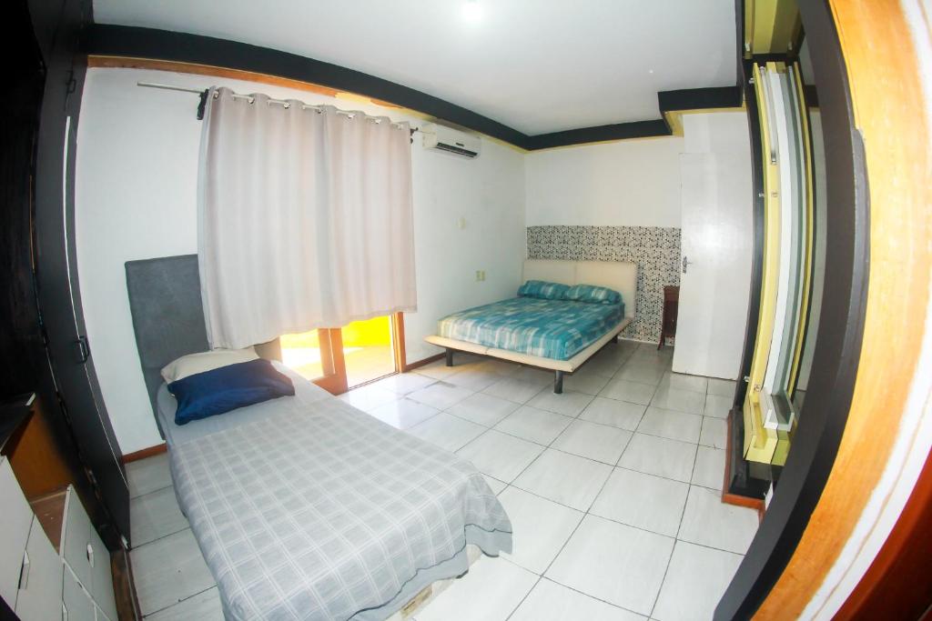 Un dormitorio con una cama y un banco en una habitación. en hostel Rep MADAGASCAR, en Florianópolis
