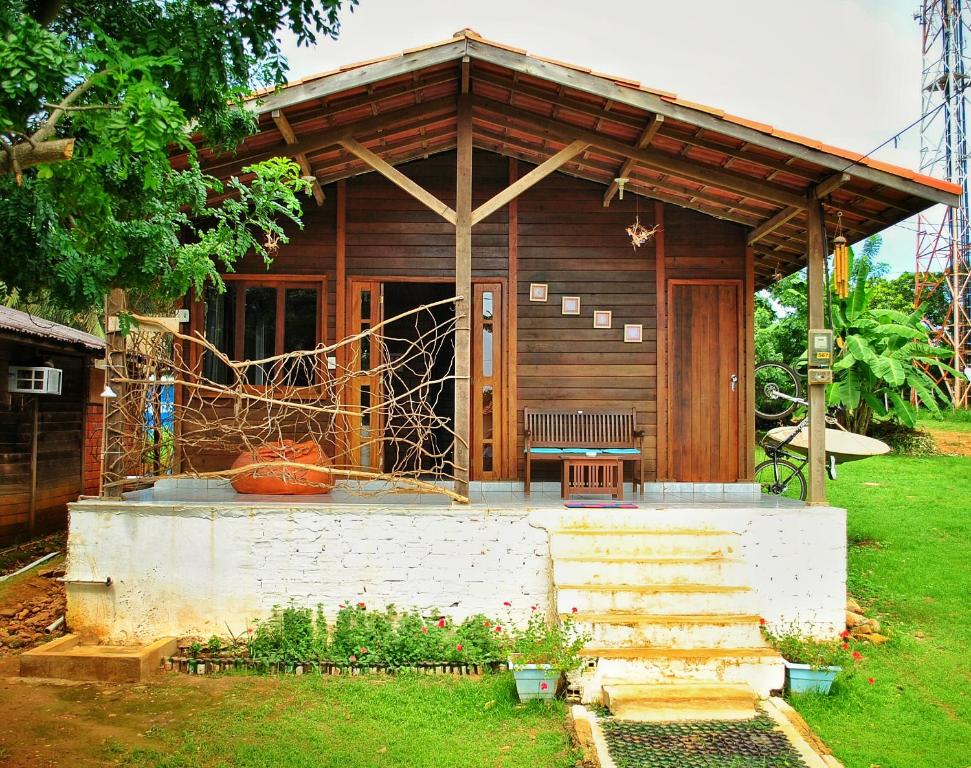 una cabaña de madera con un banco delante en Pousada Casa de Praia, en Fernando de Noronha