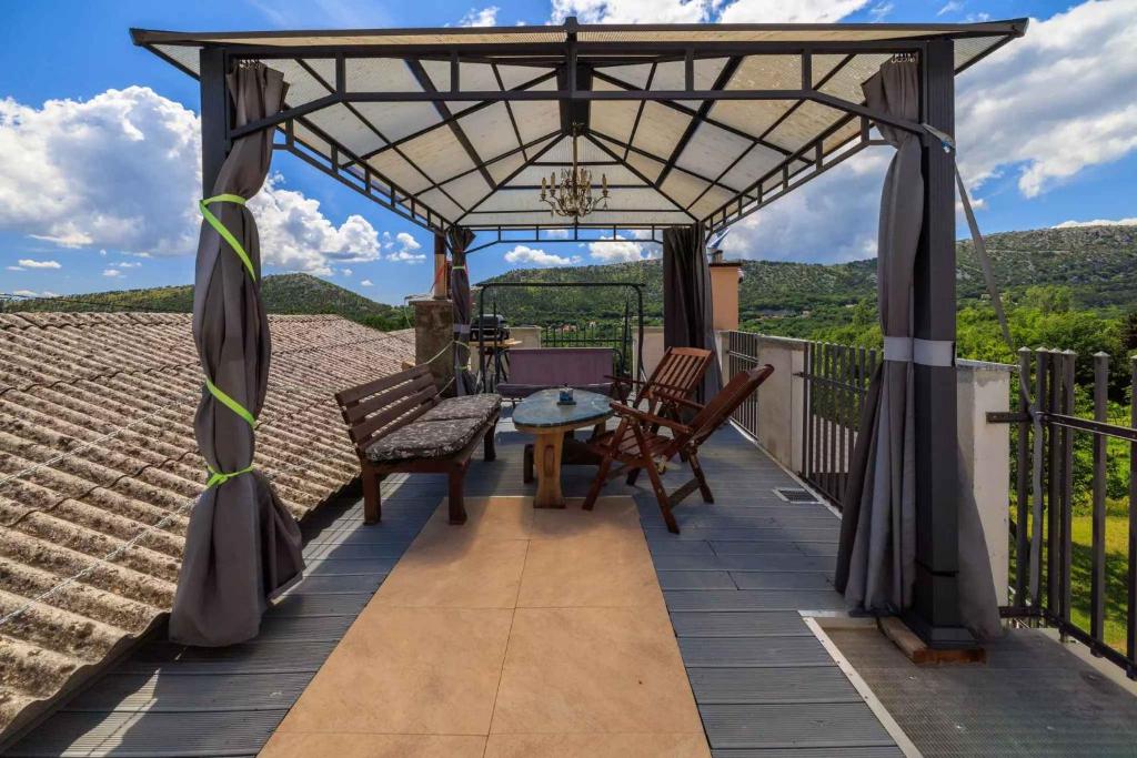 a patio with a table and chairs on a roof at Apartment in Bribir 50595 in Bribir