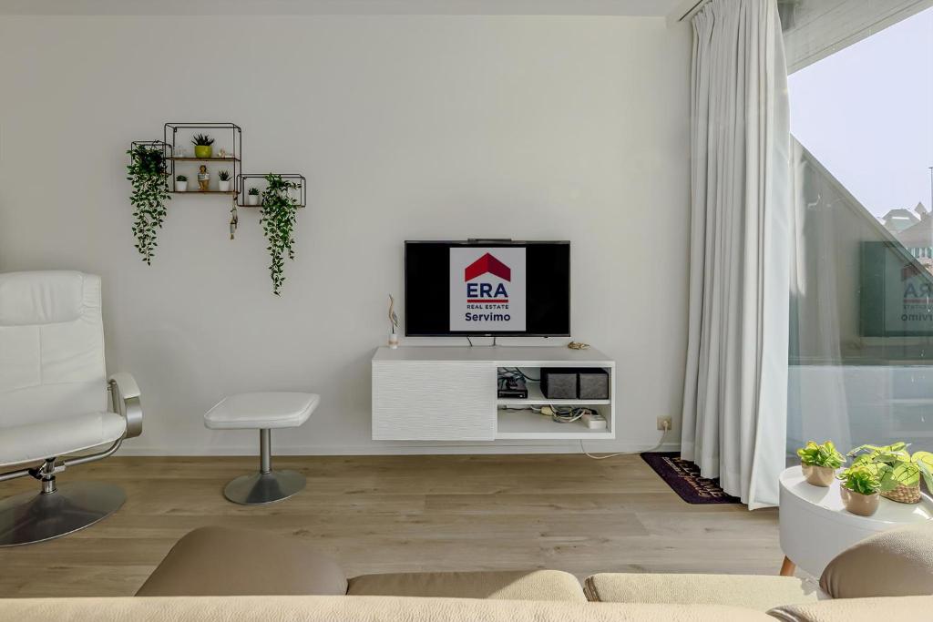 a living room with a tv on a white wall at Rietpanne 0106 in Koksijde