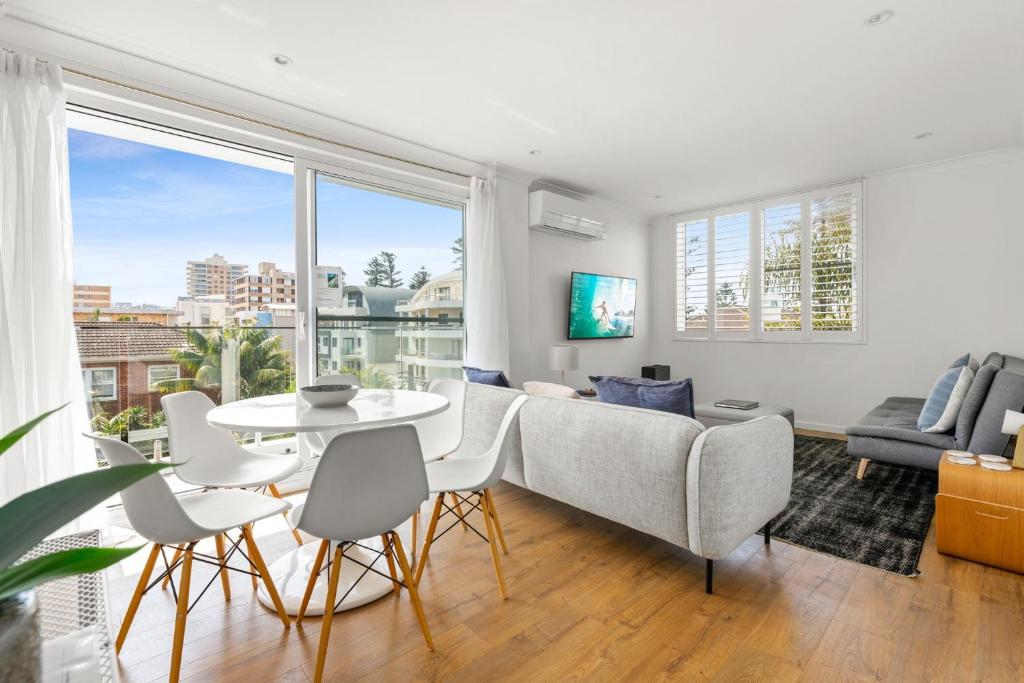 a living room with a couch and a table at Coastal 2-Bed Apartment Steps from Manly Beach in Sydney
