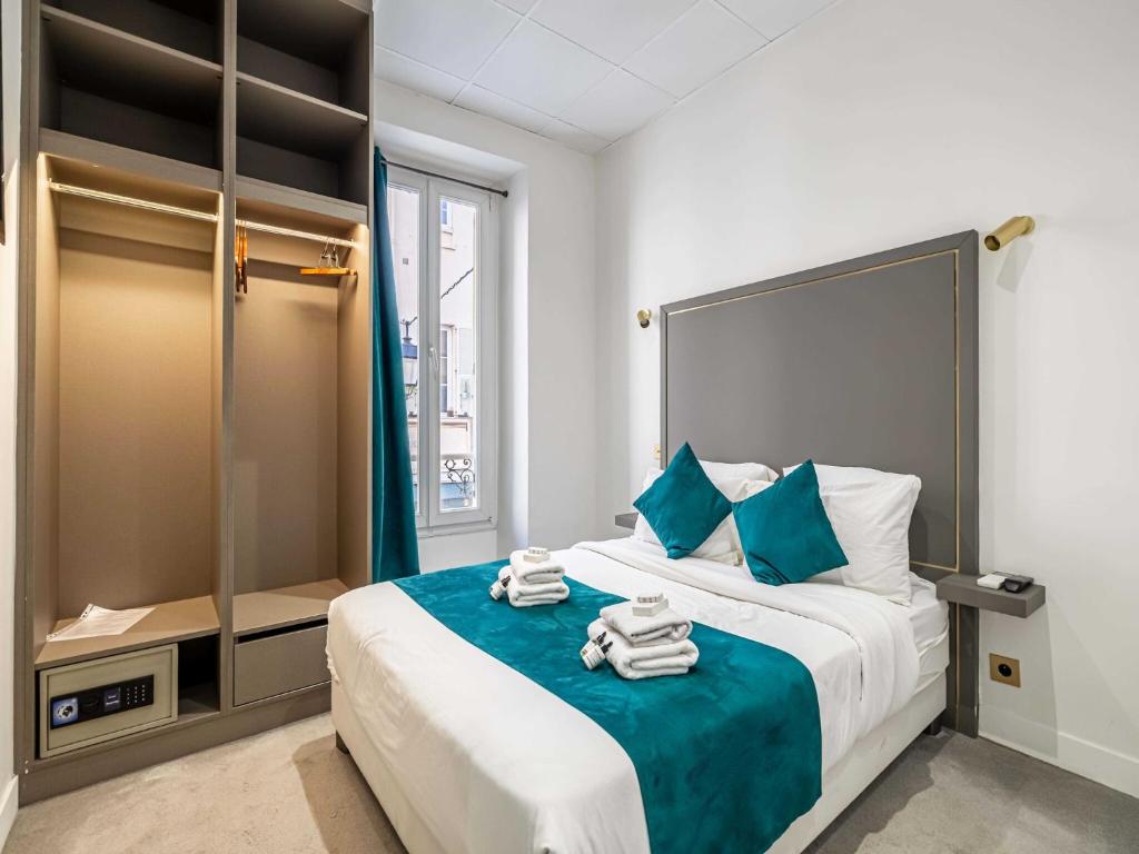 une chambre avec un grand lit avec des serviettes dessus dans l'établissement Résidence AVATON Cannes Centre, à Cannes