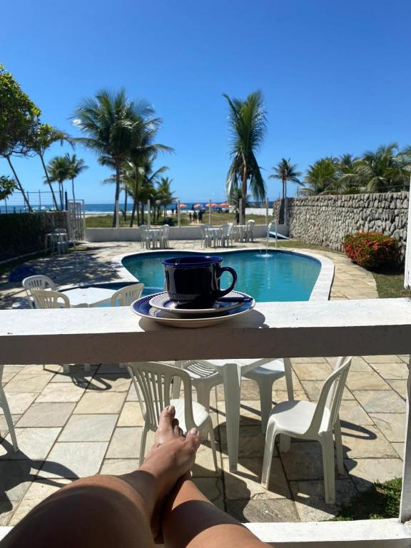 Santo AgostinhoSol Mar Hostel的一个人把脚放在桌子上，桌子上放着一杯咖啡