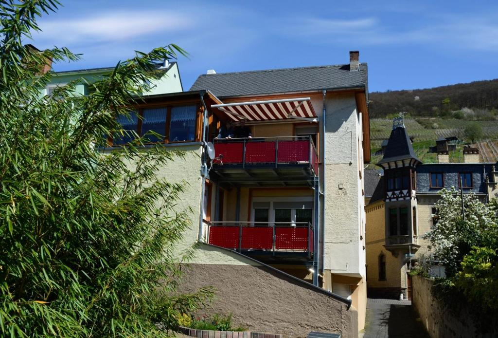 ツェル・アン・デル・モーゼルにあるFerienwohnung Weberの赤いドアとバルコニー付きの家