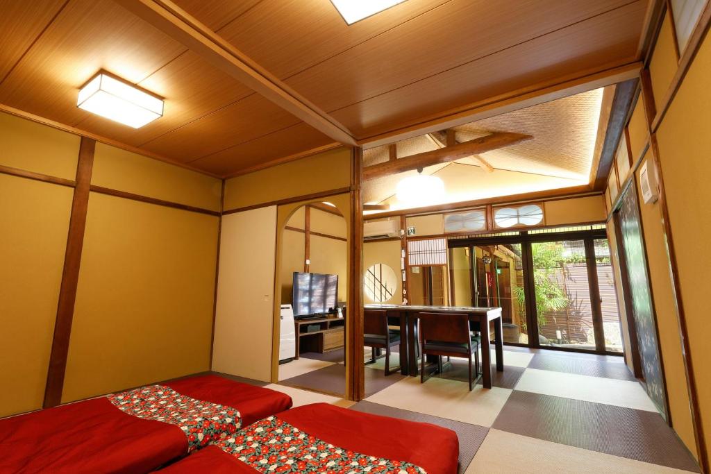 a bedroom with two beds and a dining room with a table at Kyomachiya Bettei Hanatei in Kyoto
