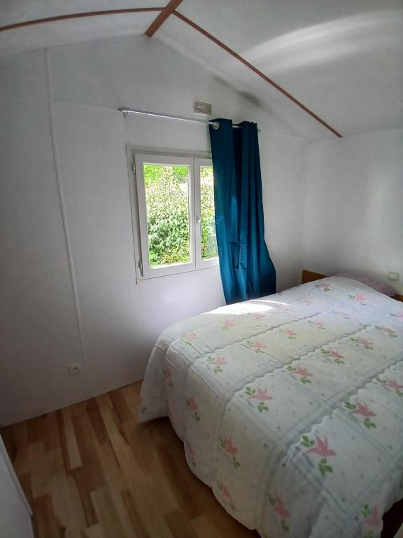 a bedroom with a bed and a window at Mobil-home confort 2 chambres à La Baule in La Baule