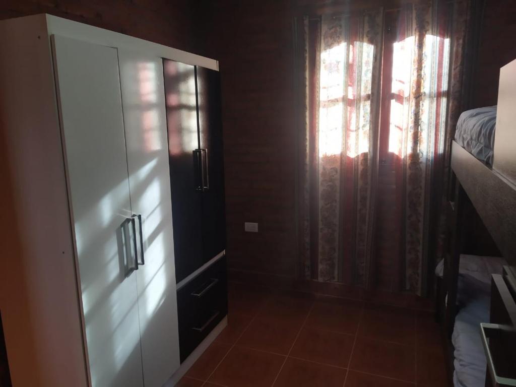 a room with a door and a window and a bedroom at Cabañas Inti Huasi in Tafí del Valle