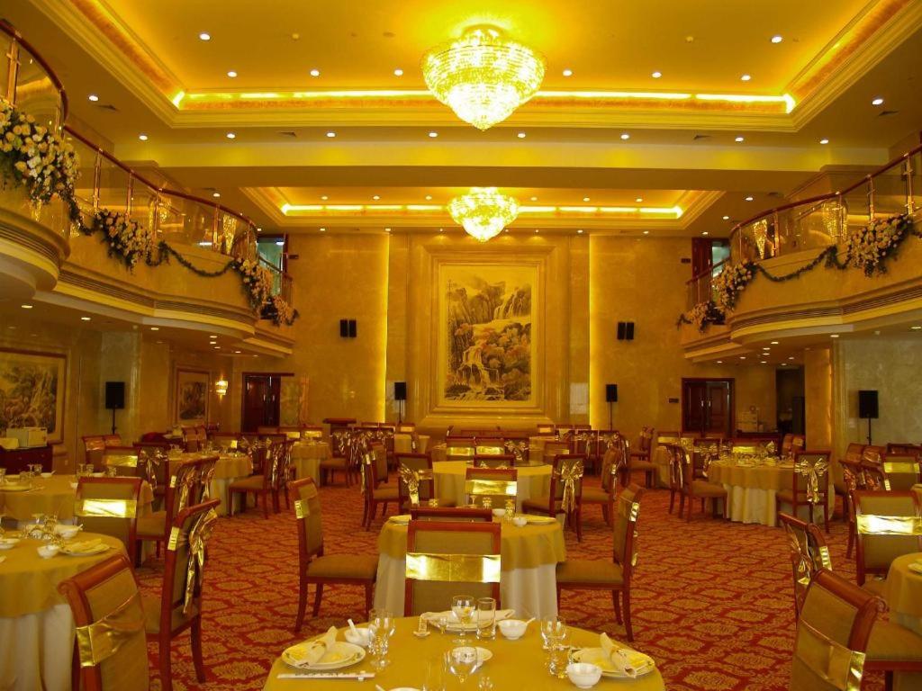 a restaurant with tables and chairs in a room at Xinhai Jinjiang Hotel in Beijing