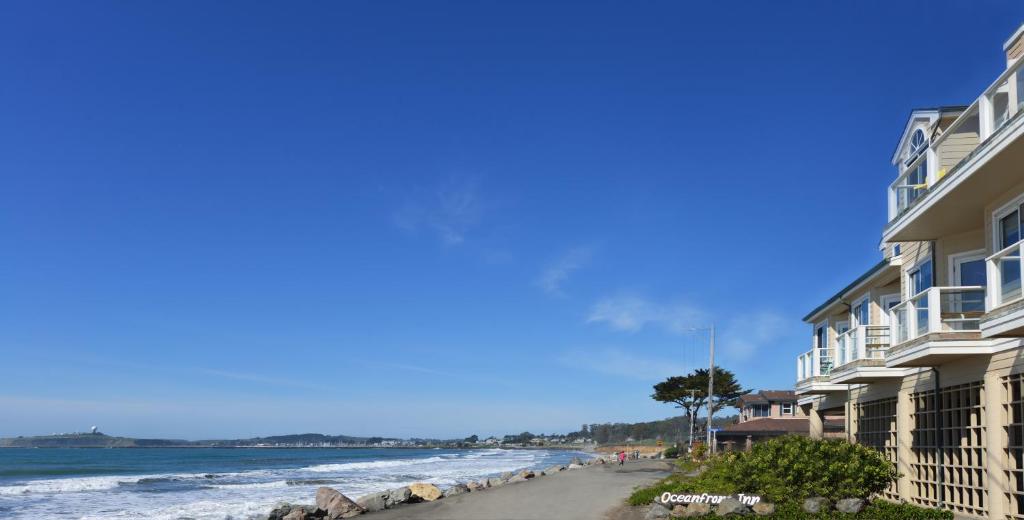 uma praia ao lado de alguns edifícios e do oceano em The Oceanfront Hotel on MiramarBeach HMB em Half Moon Bay