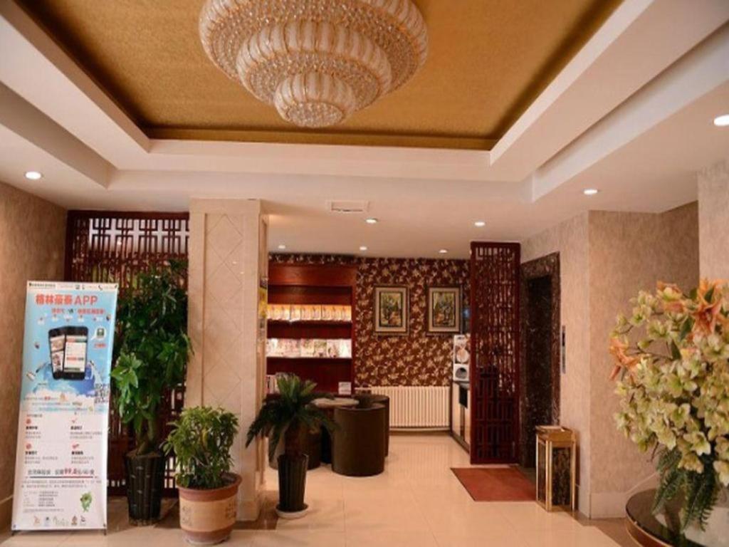 eine große Lobby mit einem großen Kronleuchter und Pflanzen in der Unterkunft GreenTree Inn Harbin Central Avenue in Harbin