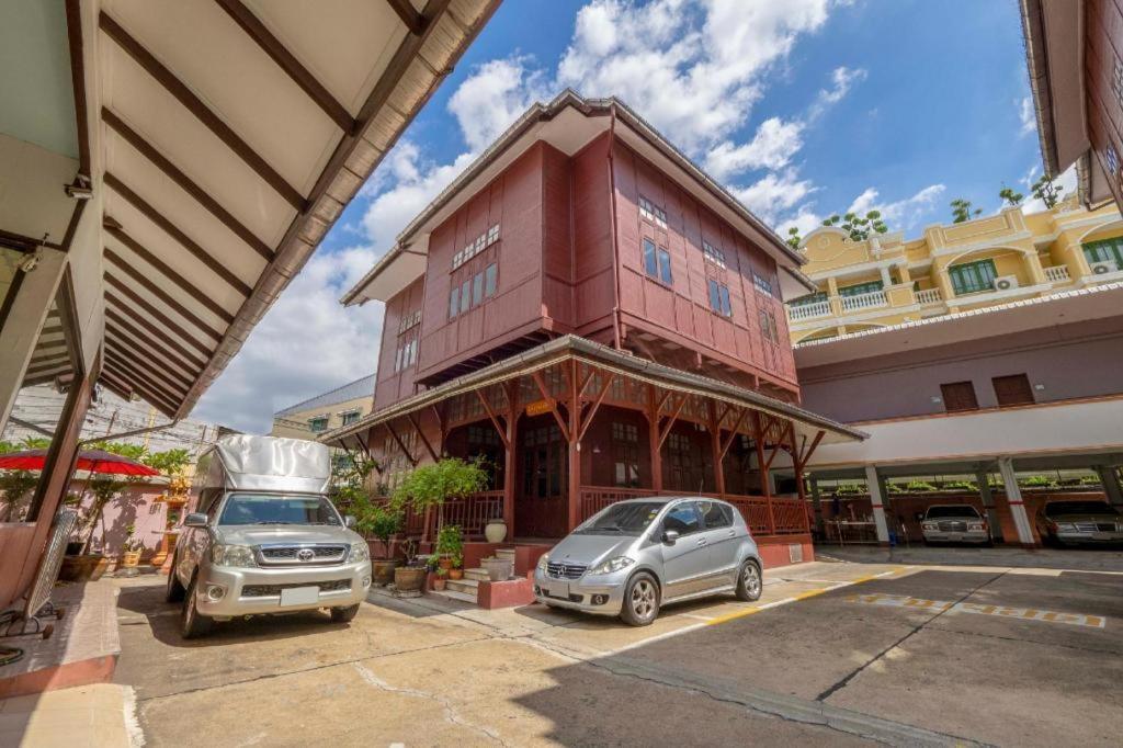 two cars parked in a parking lot in front of a building at OYO 1089 Baan Boran in Bangkok