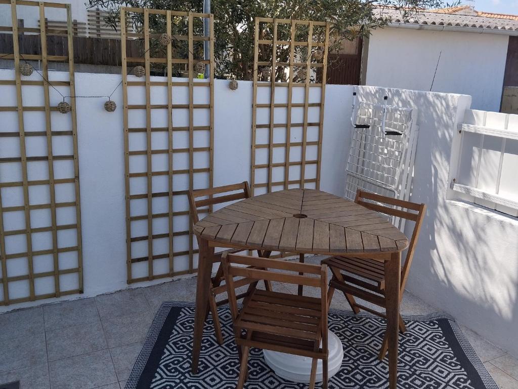 - une table en bois et 2 chaises sur la terrasse dans l'établissement Appart cosy, 4 pers, terrasse et parking, 300m plage Clémenceau, près commerces, La Tranche sur Mer - FR-1-357-285, à La Tranche-sur-Mer