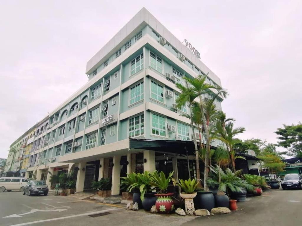 a large building with palm trees in front of it at 900 Inn in Bintulu