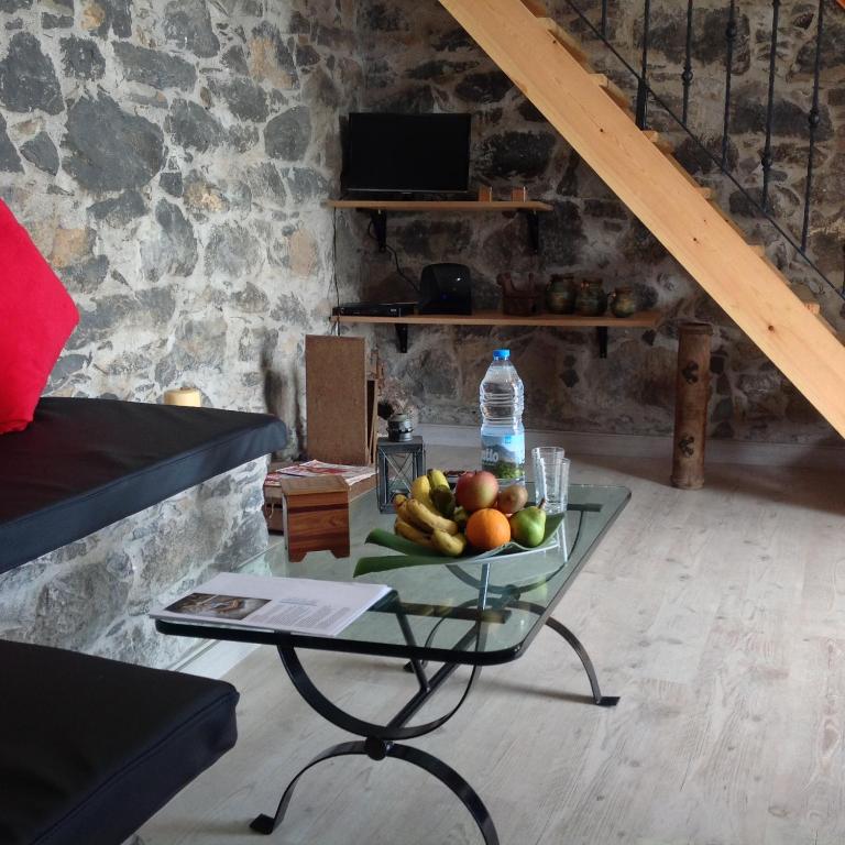 a table with a bowl of fruit and a bottle of water at Fazenda do Sousinha in Funchal