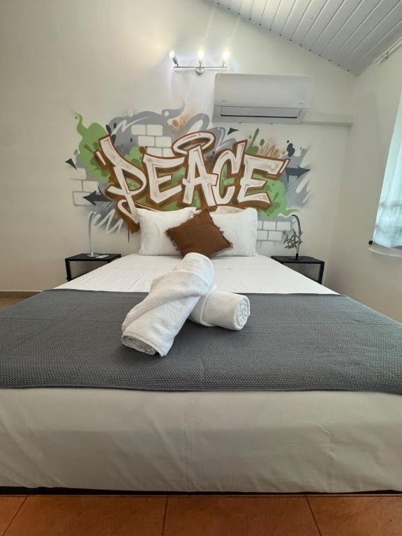 a bedroom with a large bed with a peace sign on the wall at L'urban street Cayenne in Cayenne