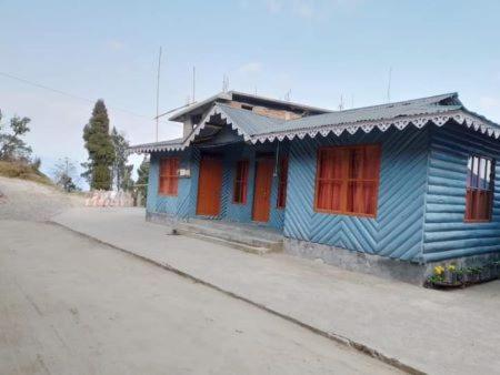 ein blaues Haus am Straßenrand in der Unterkunft EHI Homestay Rishop in Rishop