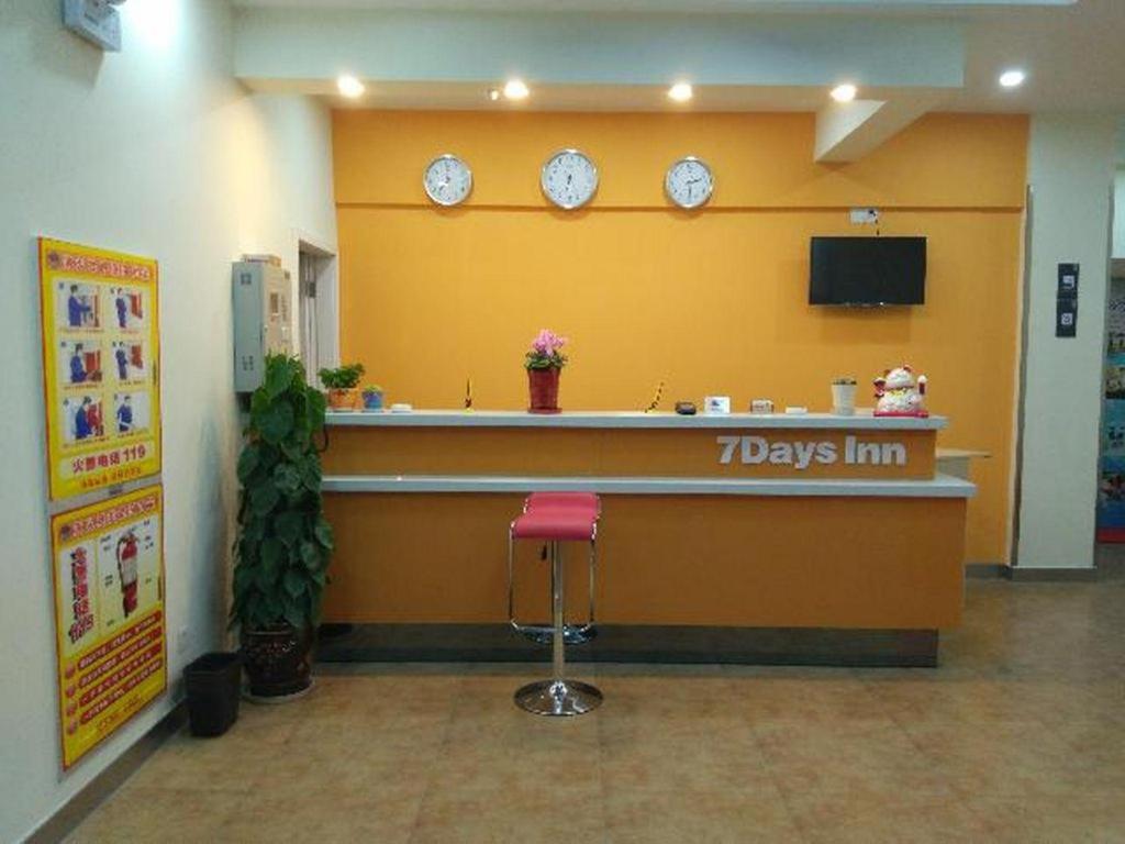 ein Wartezimmer mit einer Theke mit Uhren an der Wand in der Unterkunft 7 Days Inn Suzhou Wangting Pearl Commercial Plaza in Suzhou