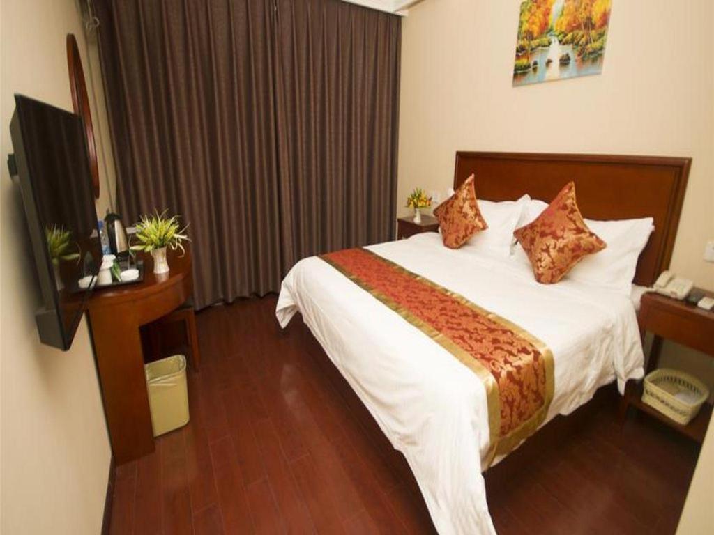 a hotel room with a bed and a television at GreenTree Inn Suzhou Shilu Walk Street West Ganjiang Road Shell Hotel in Suzhou