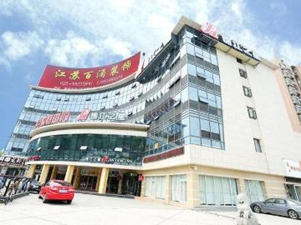 un bâtiment avec une voiture garée devant dans l'établissement Jinjiang Inn Nanjing Changjiang Bridge North Metro Station, à Taishan