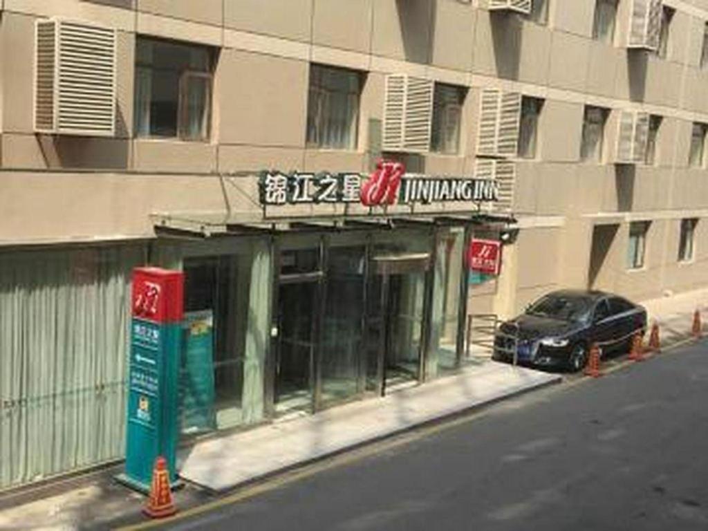a car parked in front of a building at Jinjiang Inn Beijing Conference Center Bird Nest in Beijing