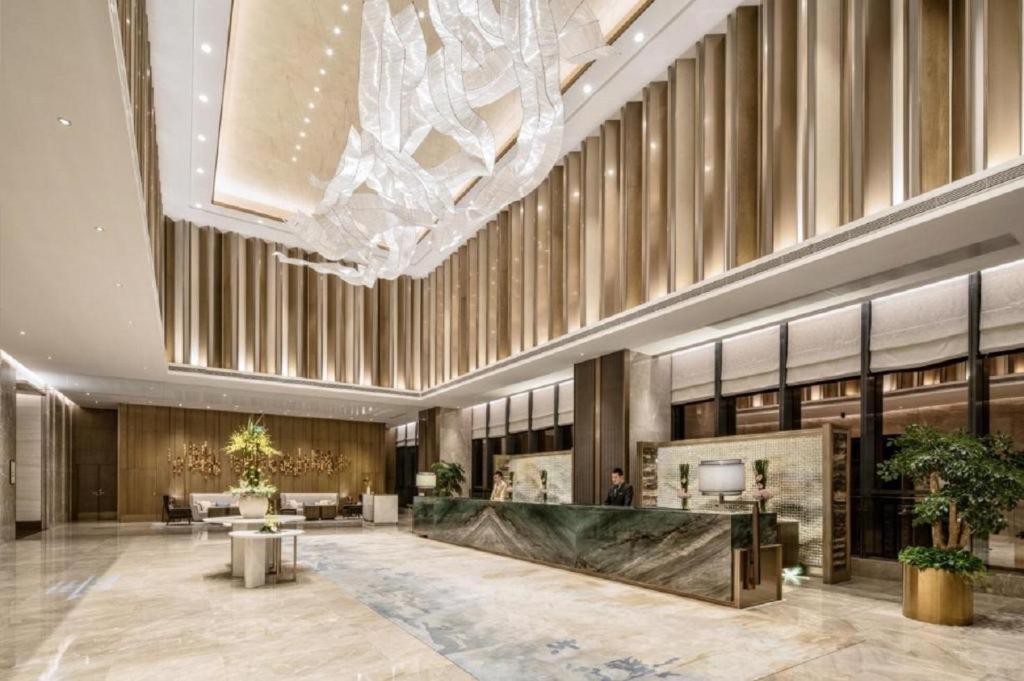 a lobby with a large chandelier in a building at Golden Eagle Summit Hotel Kunshan in Kunshan