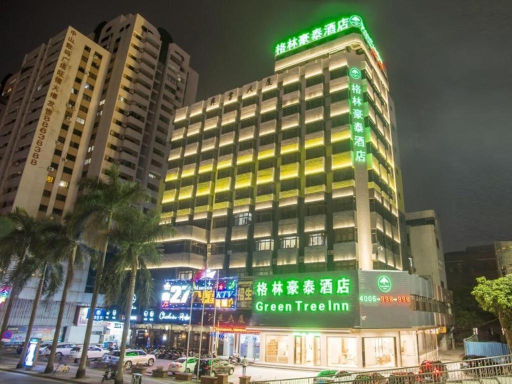 a building with a green sign on top of it at GreenTree Inn Zhongshan West District Fuhua Road Branch in Zhongshan