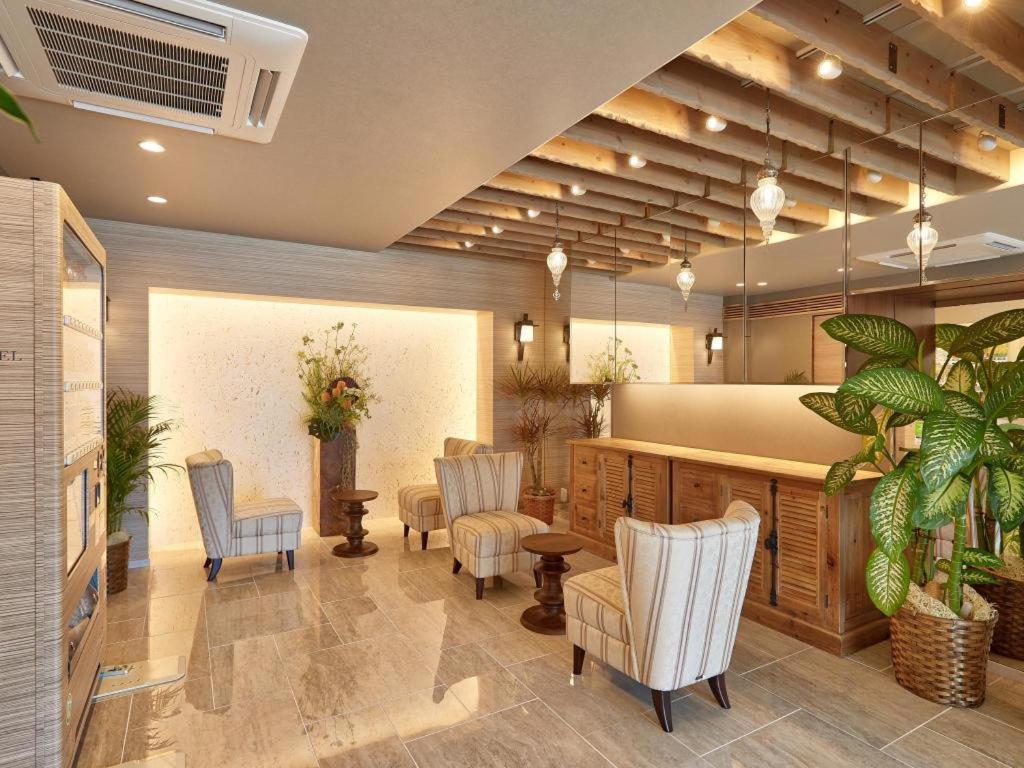 a waiting room with chairs and a table and aitating at Ryuka Hotel Naha in Asato