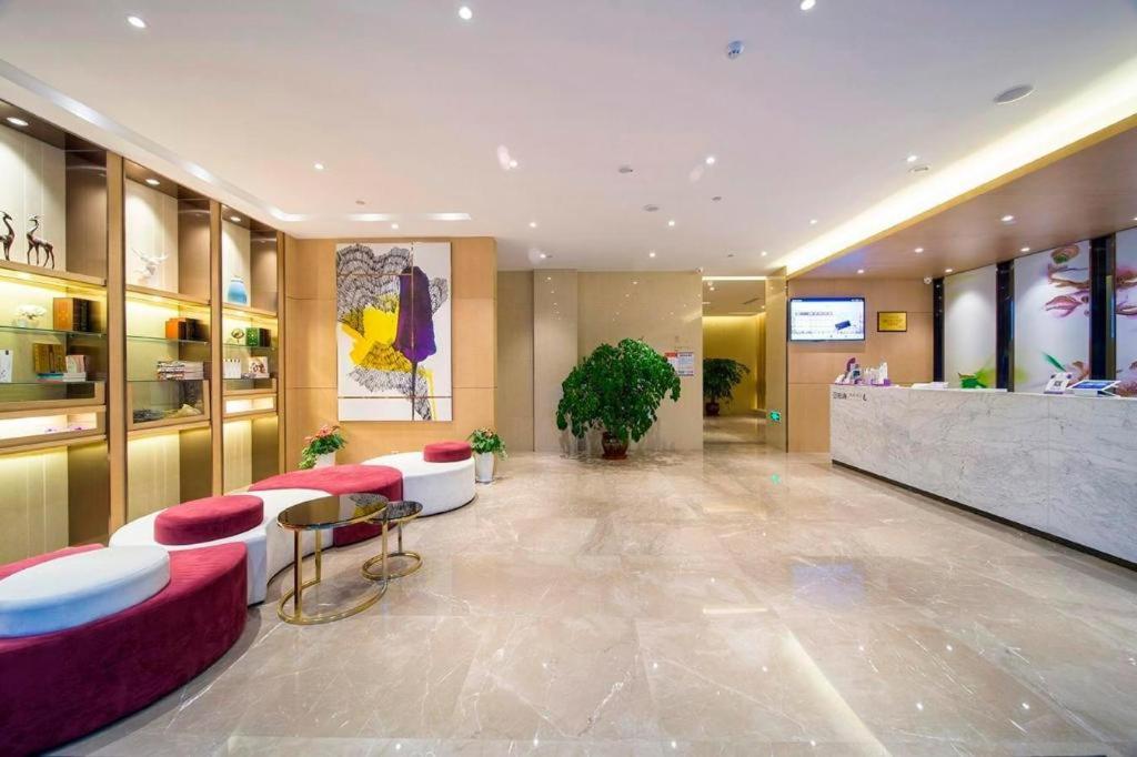 a lobby of a hotel with red chairs and a counter at Lavande Hotel Yangzhou Railway Station Jiangwang RT-Mart in Yinjiahu