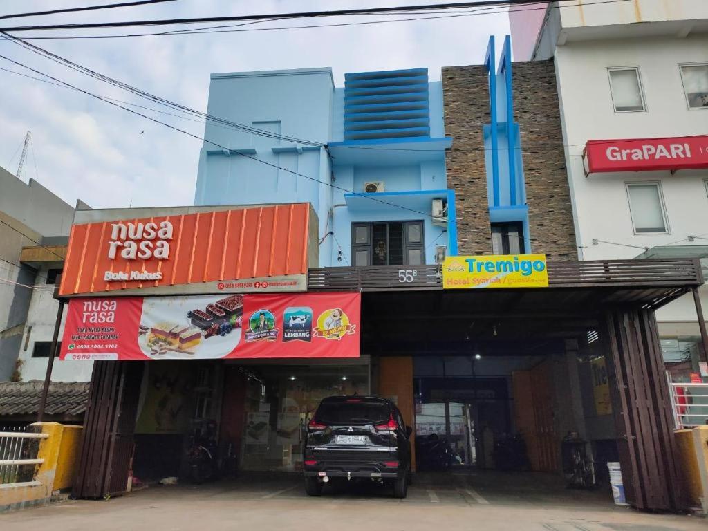 une voiture garée sur un parking devant un immeuble dans l'établissement Hotel Syariah Tremigo Guesthouse, à Cirebon