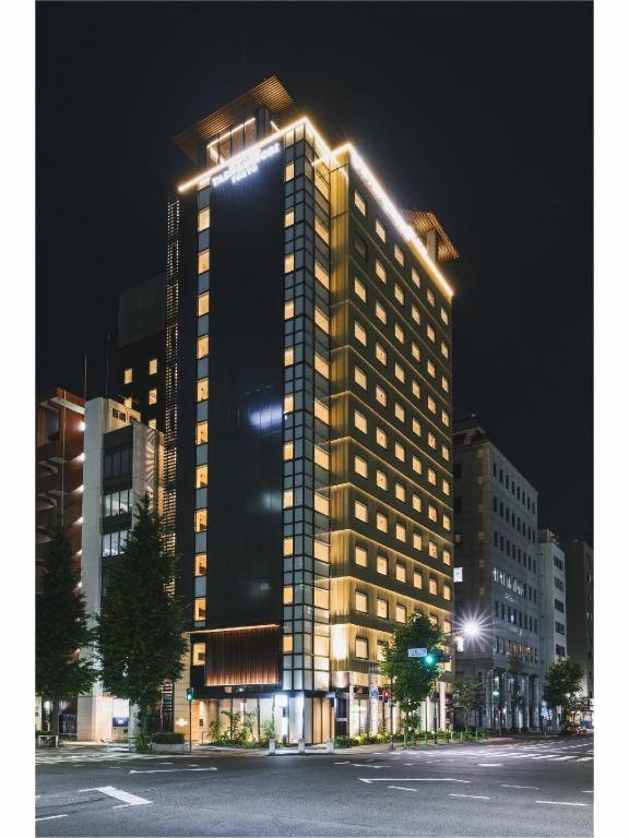 a tall building with lights on it at night at Hotel Yaenomidori Tokyo in Tokyo