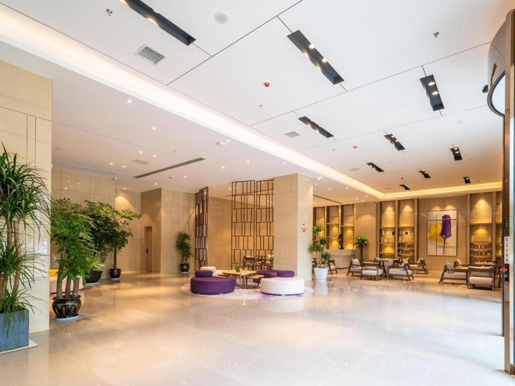 eine große Lobby mit Tischen und Topfpflanzen in der Unterkunft Lavande Hotels· Guizhou Anshun Xi Railway Station in Anshun