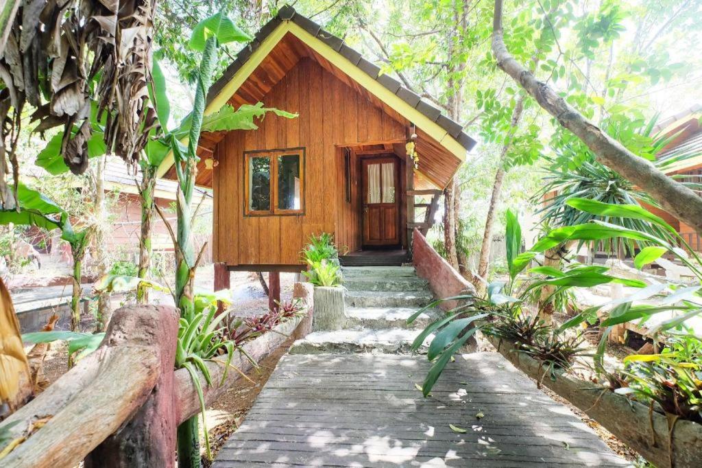 une petite cabane en bois dans une forêt avec une passerelle dans l'établissement OYO 604 Ruen Mai Horm Resort, à Ban Khok Khilek