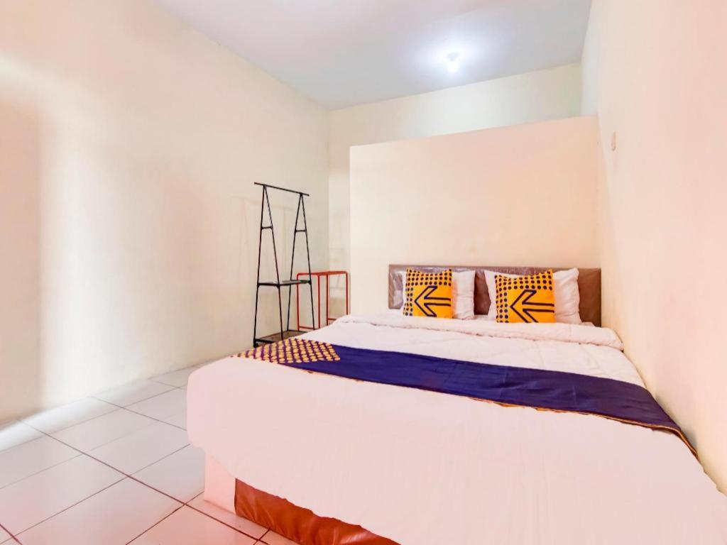 a white bedroom with a bed in a room at Hotel O Nakula Sadewa in Areman