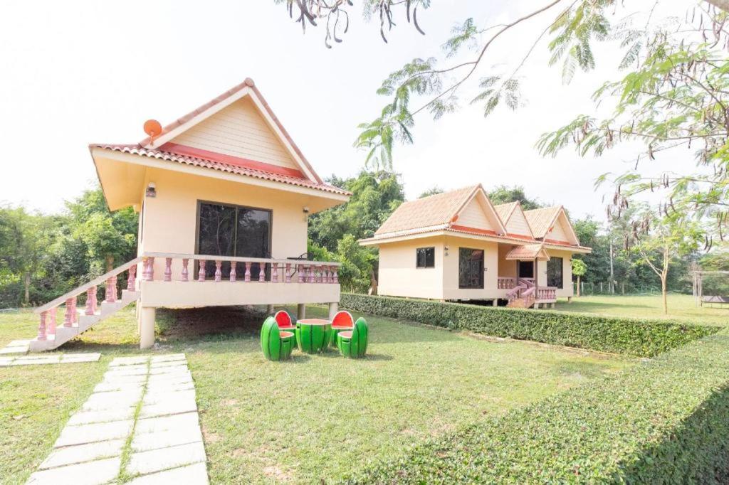 une petite maison avec des roues vertes et rouges dans la cour dans l'établissement OYO 75359 Thaiburi Thara Resort, à Ban Yan Chao